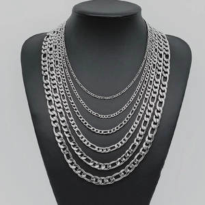 Men's silver Figaro stainless steel chain necklaces in various sizes on a black display