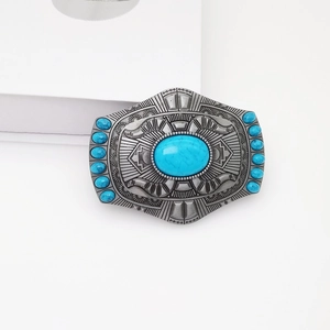 Detailed view of vintage oval belt buckle with turquoise stones and silver carvings