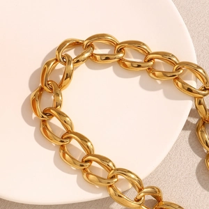 Close-up of 18K gold plated chunky link chain necklace on a white ceramic tray