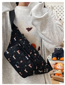 Detail of black crossbody bag with cute dachshund print and adjustable strap on model