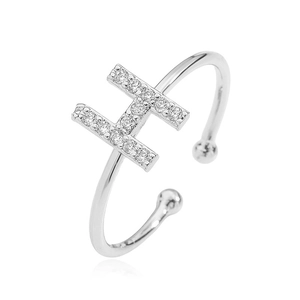 Macro detail of silver ring with letter H design and sparkling zircon stones