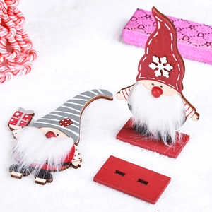 Detail of wooden Christmas gnomes with white faux fur beards and red standing base