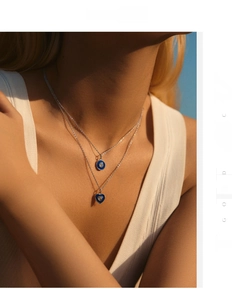 Detail of a double-layered S925 silver necklace with blue heart and round enamel pendants