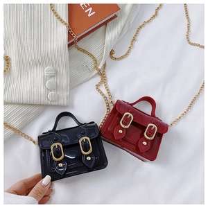 Close-up of mini glossy Cambridge bags in red and black with elegant gold chains