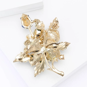 Detail view of the golden alloy rose brooch back featuring the pin and safety clasp
