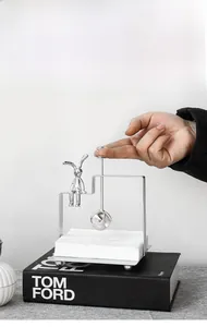 Close-up of silver iron rabbit napkin holder with a crystal ball weight on books
