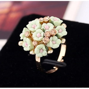 Macro shot of light green flower ring with champagne rhinestones on gold open band
