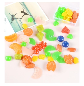Makro-Detail von sortierten PVC-Obst- und Nussmodellen mit transparenter Aufbewahrungsbox