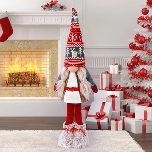 Standing Christmas gnome decoration with long legs and plush outfit by a cozy fireplace