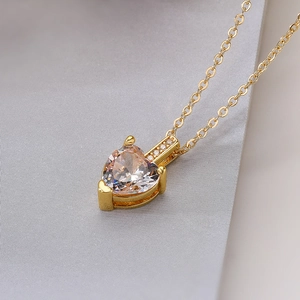 Macro shot of gold plated heart pendant necklace with shimmering cubic zirconia stone