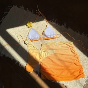 Détail d'un bikini 3 pièces dégradé avec jupe en résille et texture plissée élégante