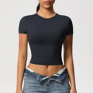 Front view of a tight black cropped fitness t-shirt styled with casual denim jeans