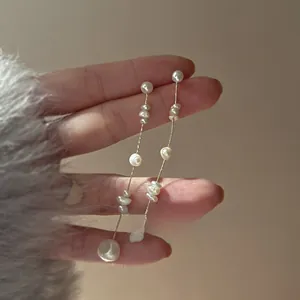 Close-up of French vintage baroque pearl tassel earrings with delicate gold chains