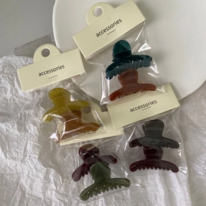 Macro shot of assorted jelly color hair claw clips with cardboard accessories packaging