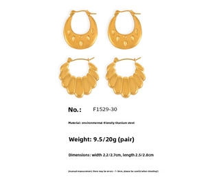 Detail of gold-plated U-shaped hoop earrings with embossed dots and scalloped textures