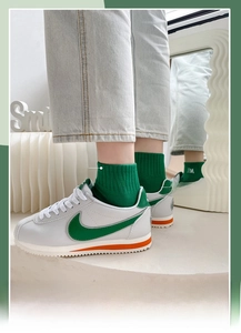 Detail of green cotton socks with NA embroidery and matching green-white athletic shoes