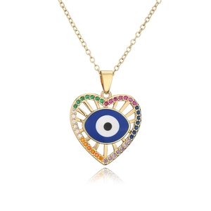 Detail view of heart pendant with blue evil eye and colorful zircon stones on gold chain