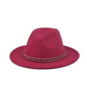 Vue détaillée d'un chapeau fedora en feutre fuchsia avec chaîne décorative assortie