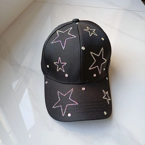 Fashionable black baseball cap featuring colorful rhinestone stars on a marble surface