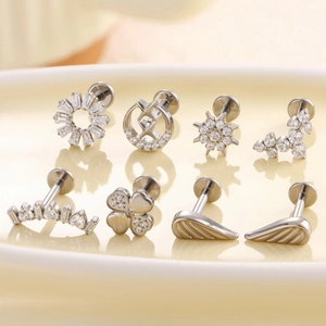 Titanium clover labret studs with zircon insets shown in various celestial designs