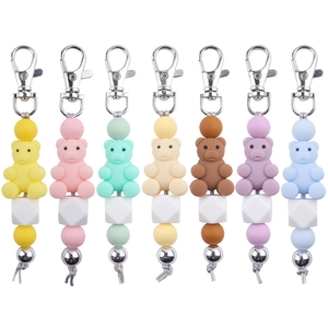 Flat lay of colorful silicone bear keychains in seven various pastel shades on white background