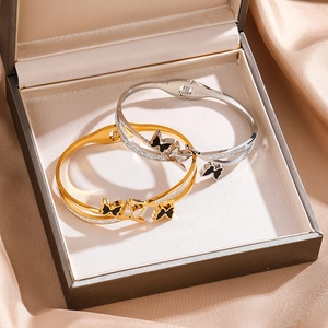 Detail of gold and silver butterfly bangles with zircon stones in a gift box