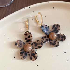Detail of 18K gold-plated acetate flower earrings with leopard print and zircon accents