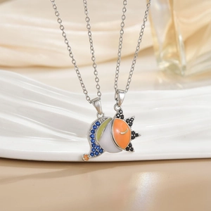 Matching sun and moon couple necklaces with 18k gold plating on white wave tray