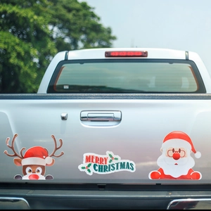 Magnetic Christmas car decals with Santa and Reindeer on a white pickup truck tailgate
