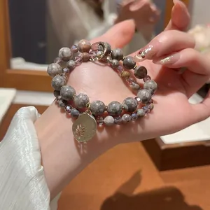 Double-layer beaded bracelet with grey stone, purple crystal and gold leaf pendant