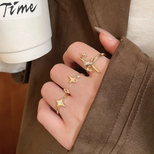 Close-up of gold starburst ring set with white zircons on hand with coffee cup