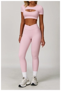 Detail view of pink yoga set showing front cutout top and cross-waist leggings detail