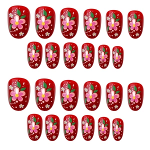 Elegant red French press-on nails with hand-painted floral patterns and white polka dots