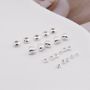 Close-up of S925 sterling silver spacer beads in heart, round, and square shapes