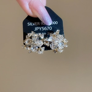 Macro shot of 925 silver flower stud earrings with shimmering cubic zirconia crystals