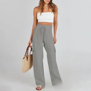 Detail of high-waist grey cargo pants with drawstring waist and large flap pockets