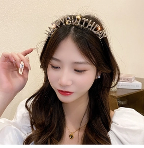 Close-up of golden Happy Birthday headband with sparkling rhinestones on model
