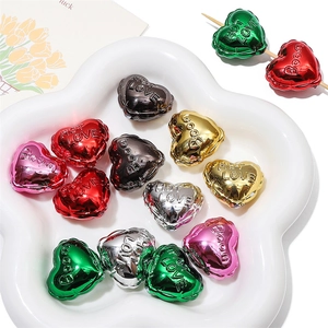 Close-up of multicolored acrylic heart beads with metallic finish and embossed lettering