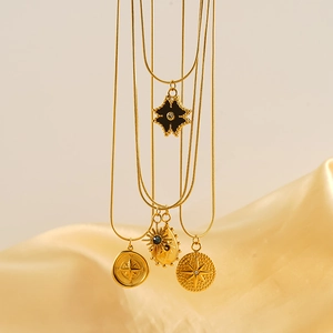Gold plated tarot pendant necklaces with compass and star designs on silk fabric