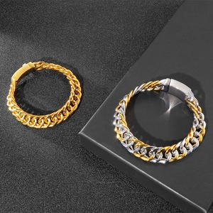 Detailed view of gold and silver cuban chain bracelets on a black textured background