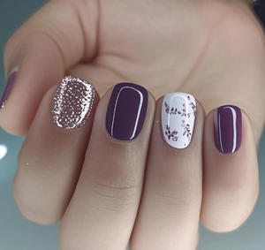 Detail of short square press-on nails with purple glitter and floral leaf patterns