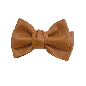 Elegant brown faux leather pleated bow accessory with fine texture on white background