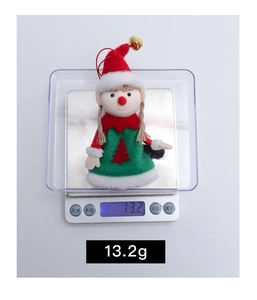 Detail showing the 13.2g weight of the cute Christmas elf doll on an electronic scale