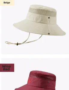 Detail of outdoor sun hats in beige and wine red with breathable mesh and mountain embroidery