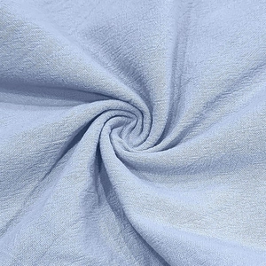 Gros plan sur le tissu en lin bleu clair montrant la texture et les plis naturels