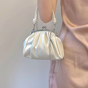 Detail of elegant pleated cloud clutch with metal kiss lock and fine chain strap