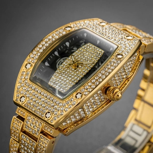 Macro detail of gold tonneau watch with full diamond setting and black mechanical dial