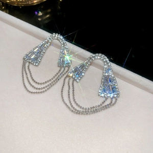 Détail de boucles d'oreilles géométriques argentées à pampilles en zircon sur écrin velours
