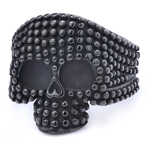 Dettaglio macro di anello teschio punk con perline nere e finitura in acciaio inossidabile