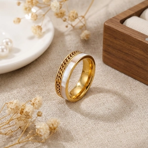 Bague chaîne hip-hop dorée avec nacre et diamants sur tissu en lin beige naturel